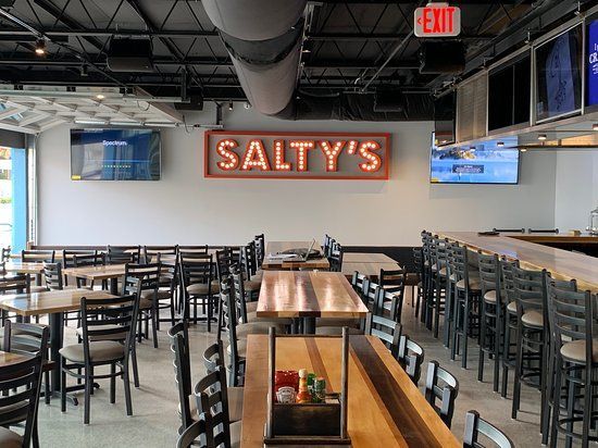 A restaurant with tables and chairs and a sign that says salty 's