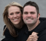 A man and a woman are posing for a picture and smiling for the camera.