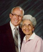 A man and a woman are posing for a picture together and smiling.