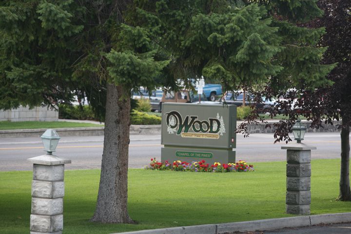 A sign that says wood is in the middle of a park