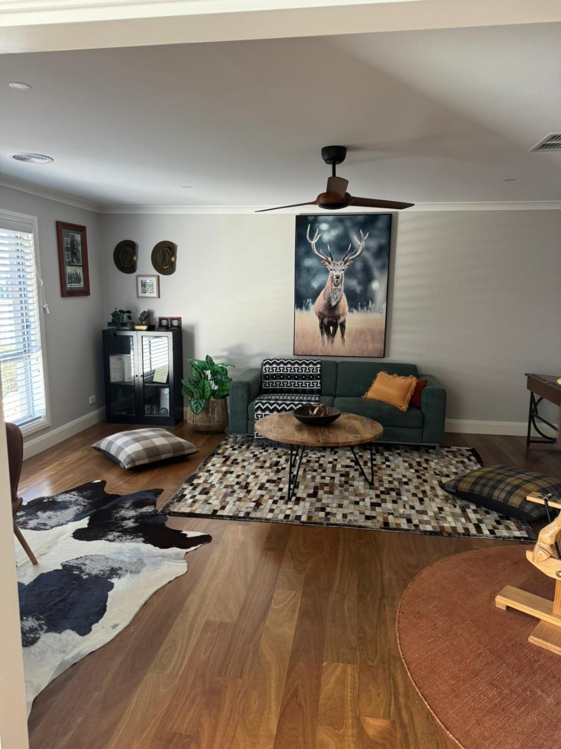 Living Room With Teal Sofa, Deer Art, and Round Coffee Table— Andrew Harper Painting & Decorating in Albury, NSW