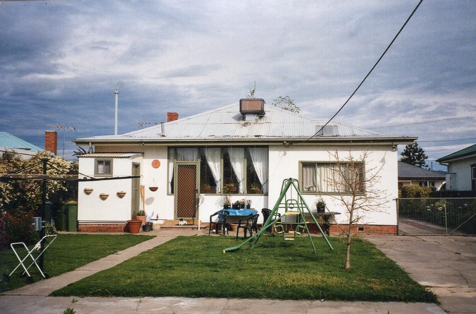 White suburban house with a swing set, small yard, and overcast sky — Andrew Harper Painting & Decorating in Albury, NSW