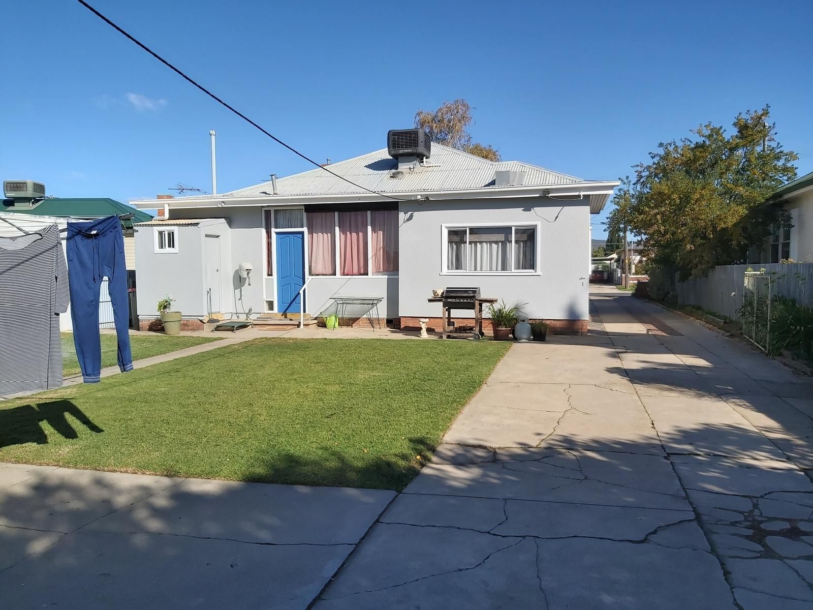 Small grey house with blue door and green lawn — Andrew Harper Painting & Decorating in Albury, NSW