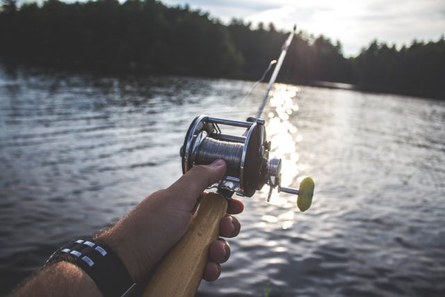 A person is holding a fishing rod over a body of water.