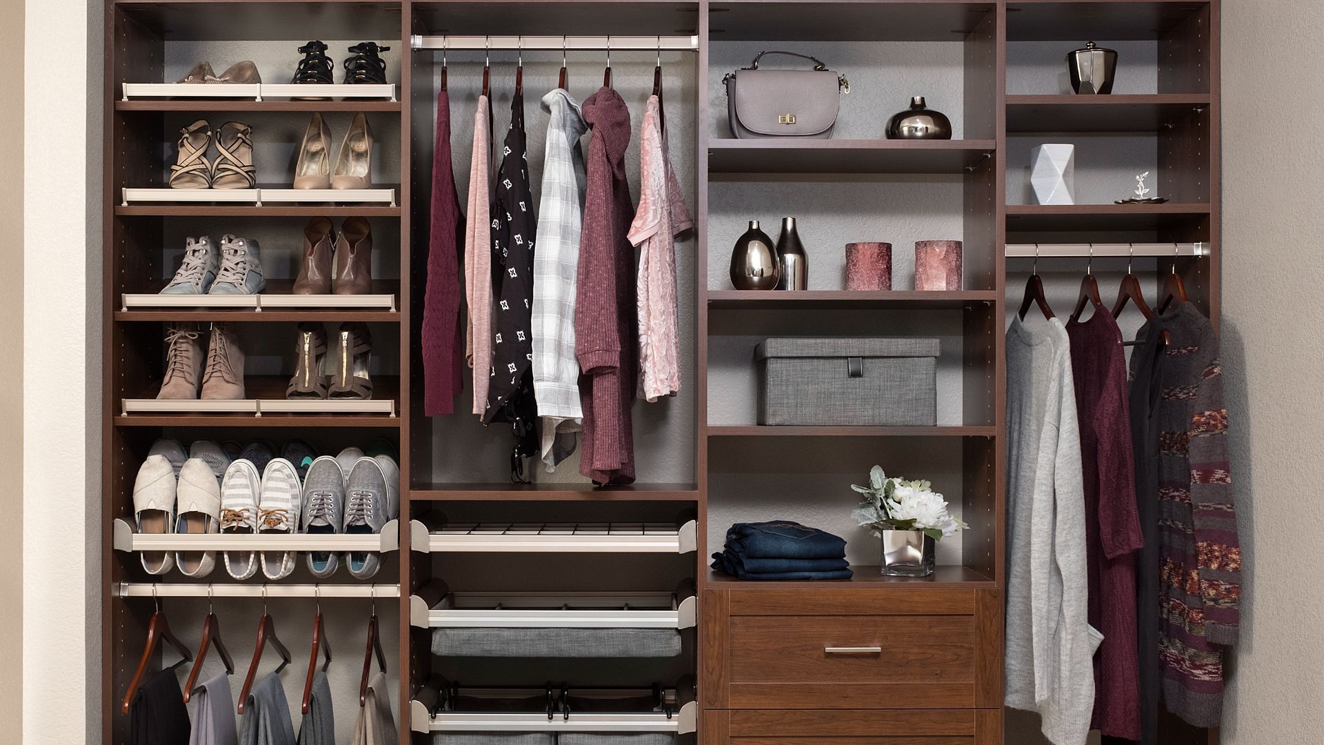 A coco shaker style finish closet filled with lots of clothes and shoes.
