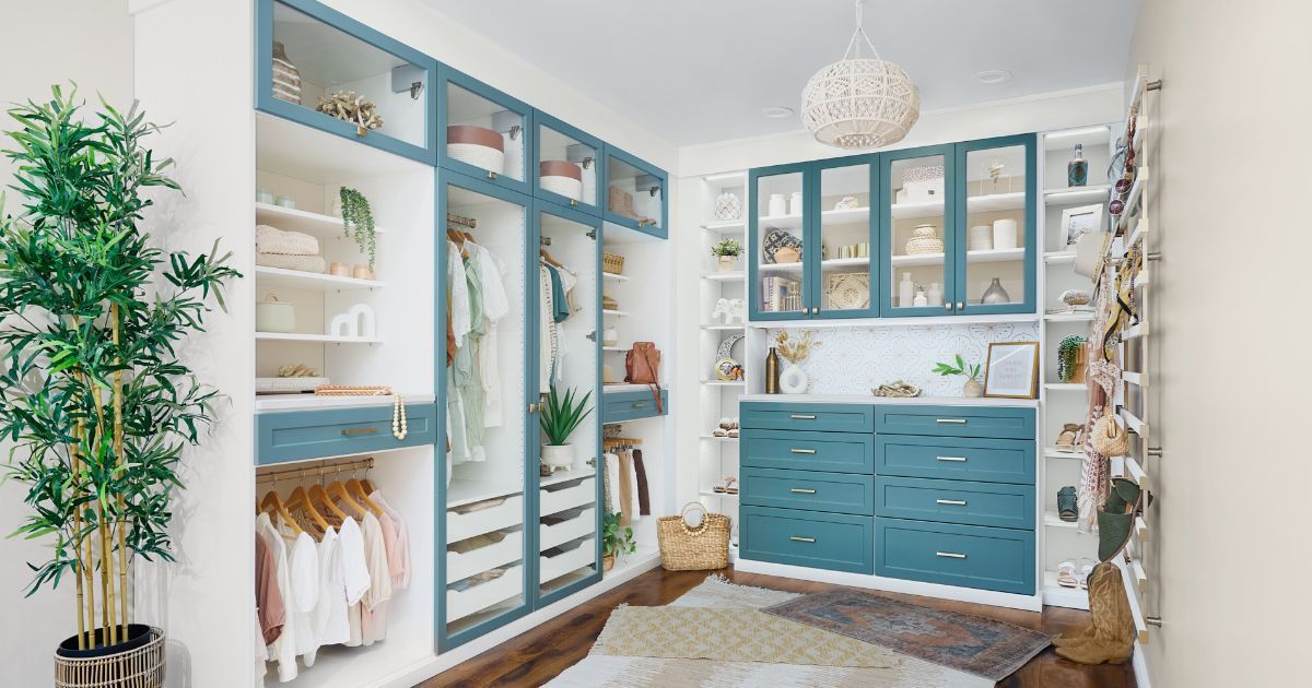 A lagoon and white finished walk in closet with blue cabinets and white shelves.
