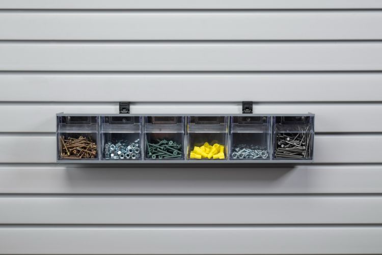 A shelf filled with various types of screws and nails on a wall.
