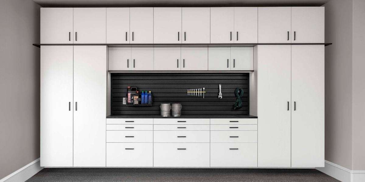 A white garage cabinet with a lot of white drawers and cabinets