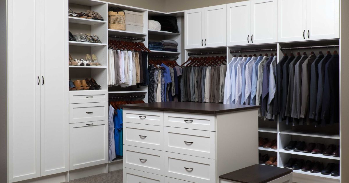 A walk in closet filled with lots of clothes and shoes.