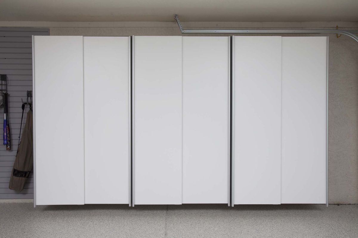 A row of white sliding doors in a garage.