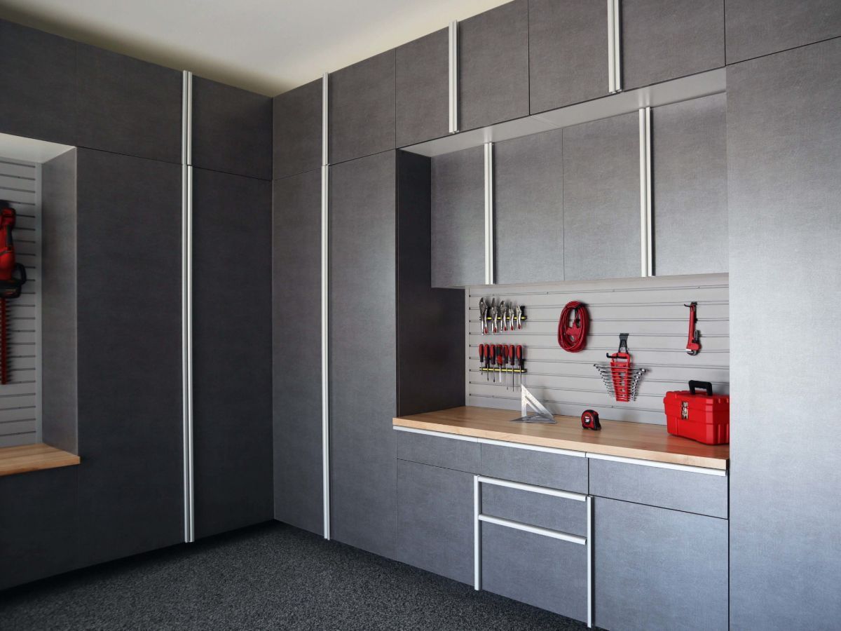 A garage with gray cabinets and a wooden counter top