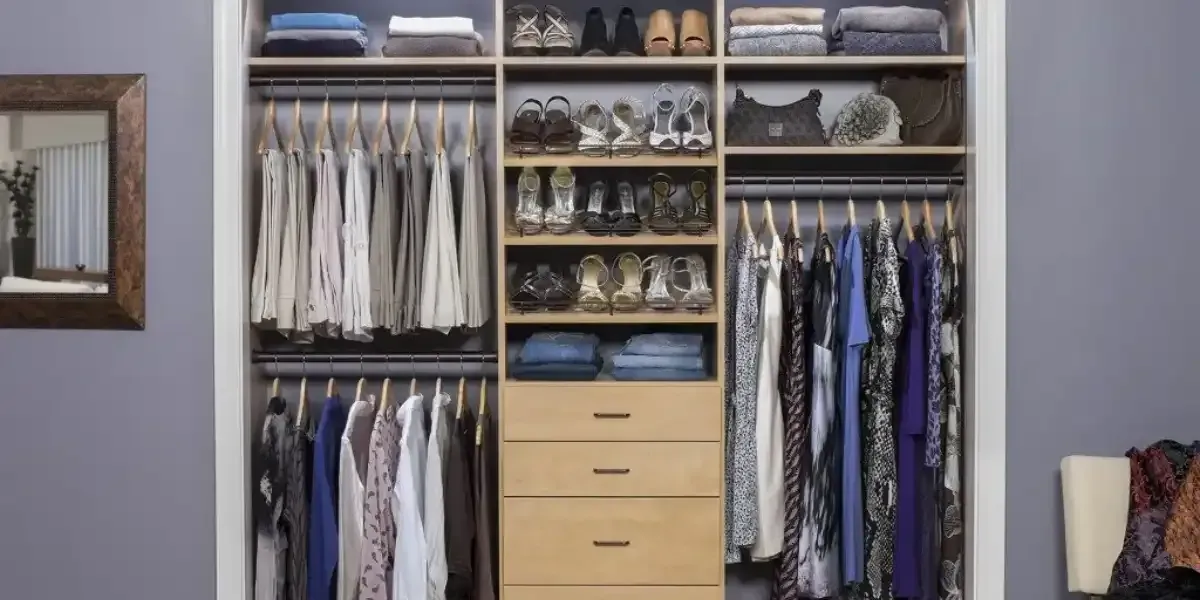 A reach in closet filled with lots of clothes and shoes.