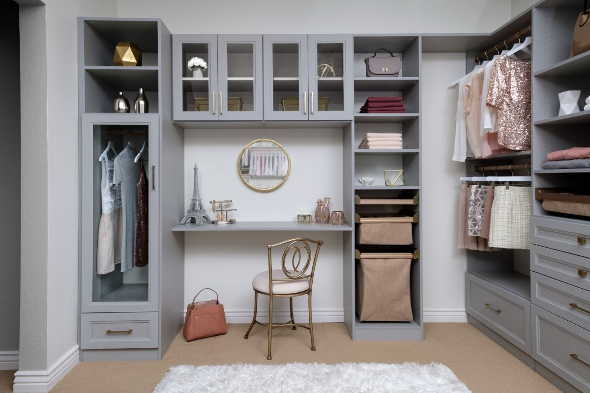 A walk in closet with a desk and chair