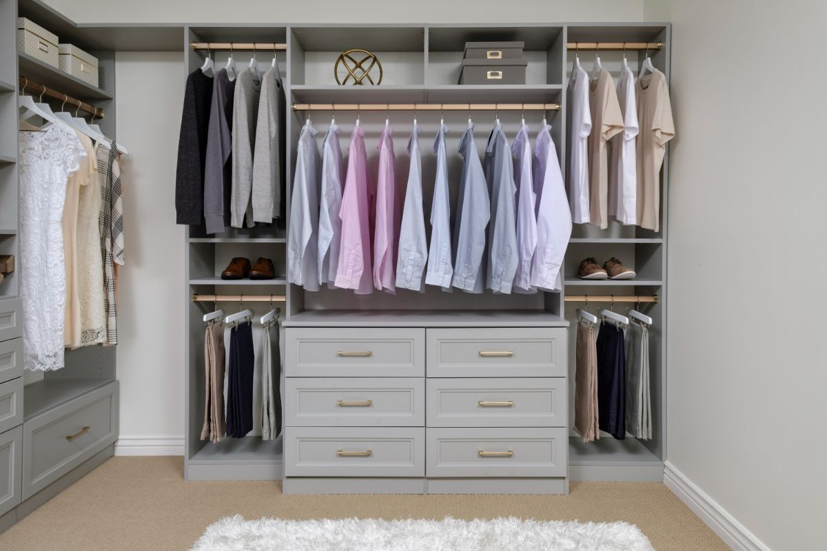A walk in closet filled with clothes and dressers.