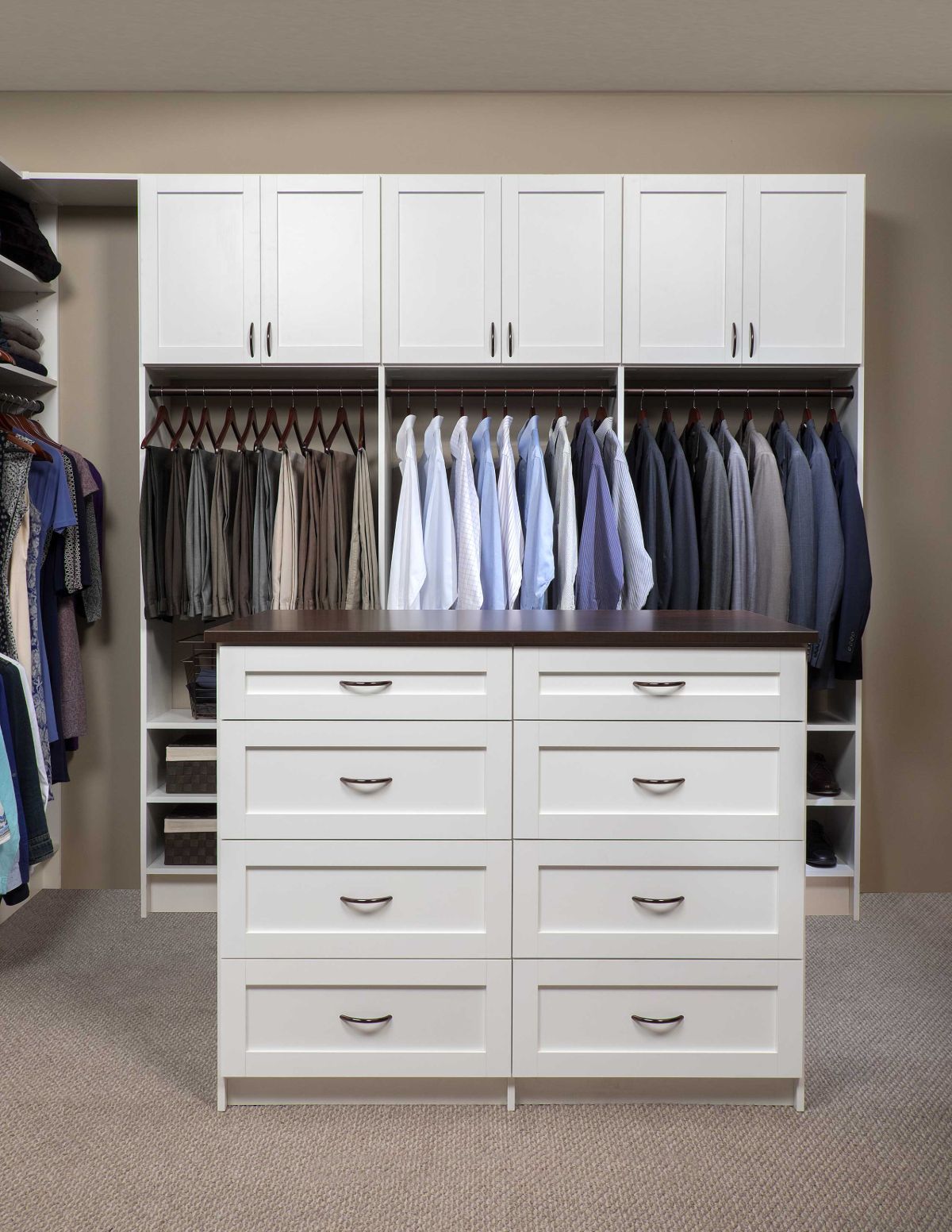A walk in closet filled with lots of clothes and a dresser.