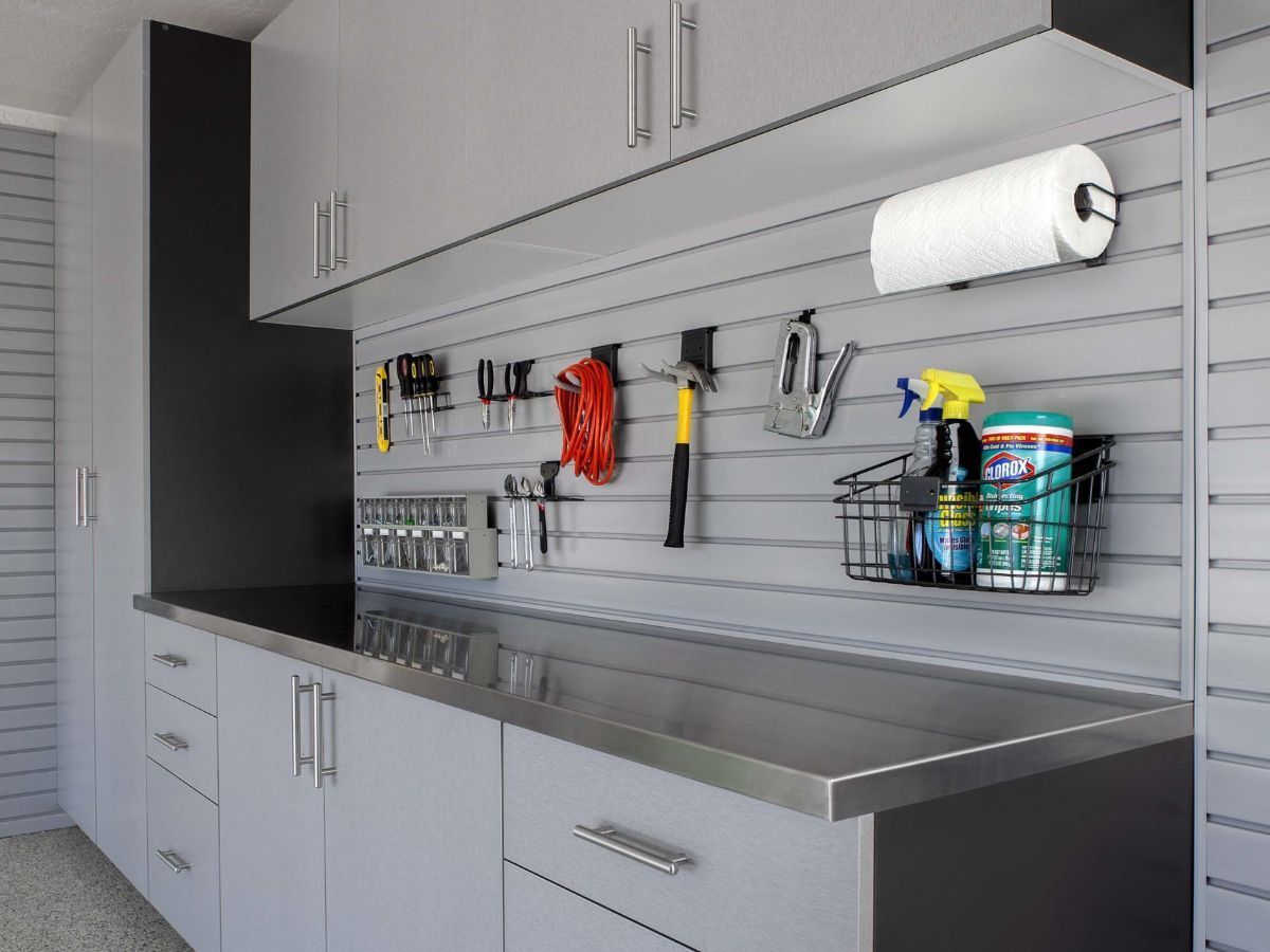 A garage with gray cabinets and a stainless steel counter top.