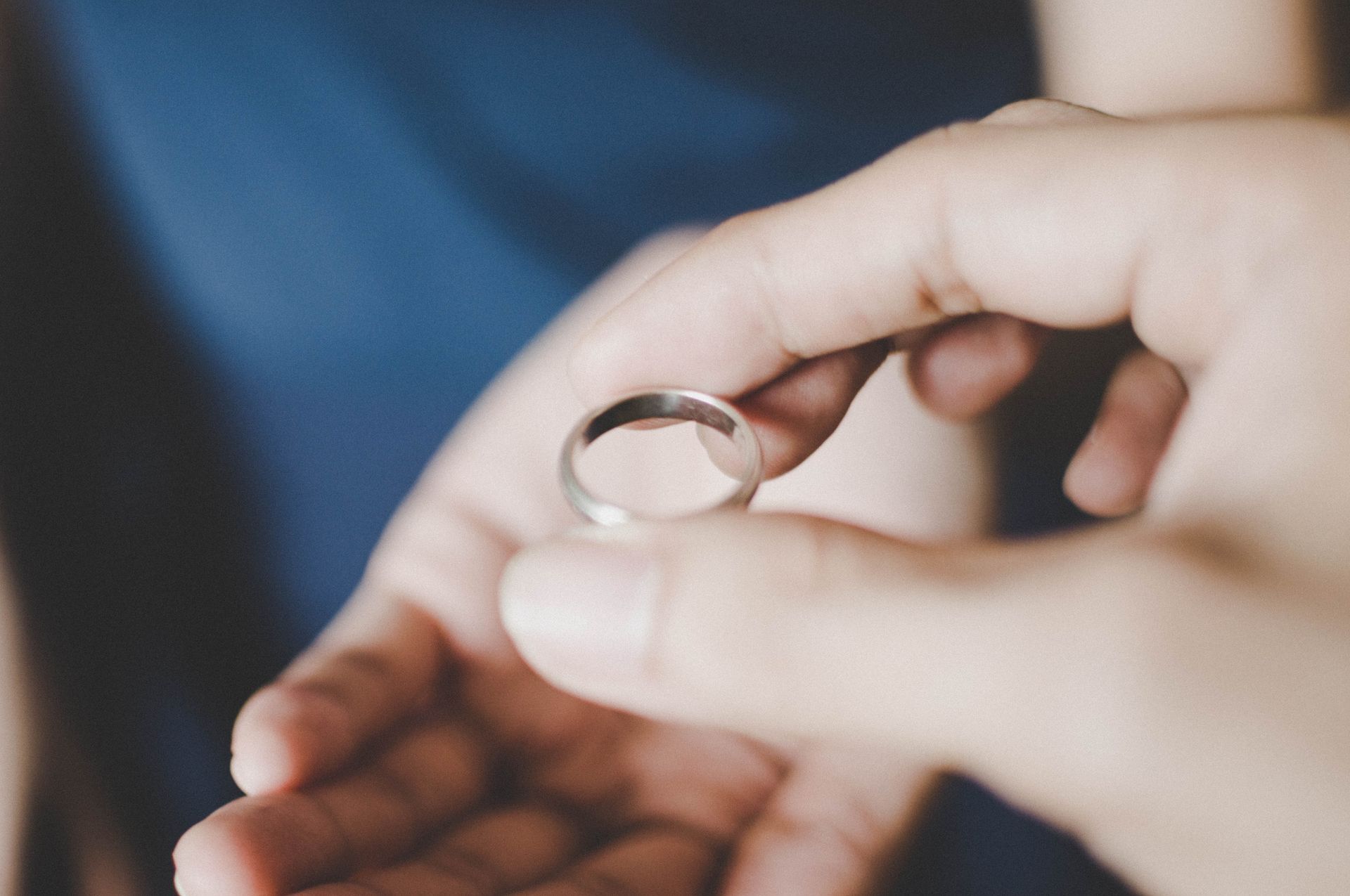 A man is putting a wedding ring on a woman 's finger.