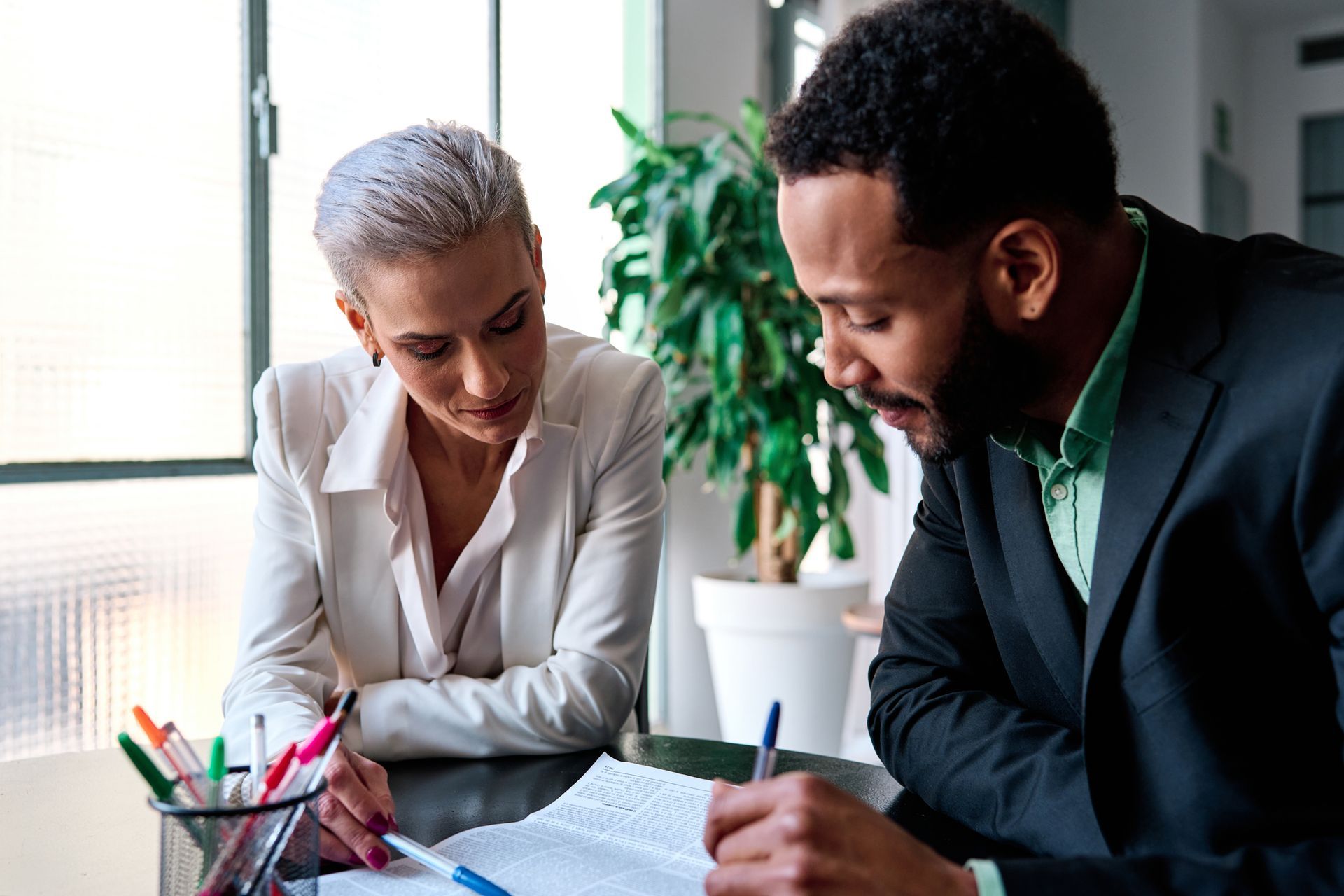 A lawyer is reading a document during a meeting with a client.