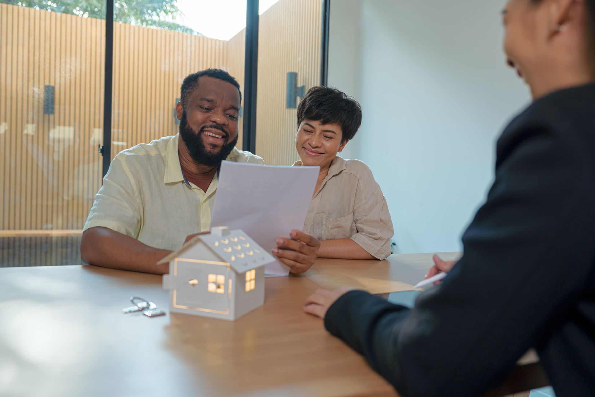 A couple with a local real estate attorney reading a purchase agreement about buying a house.