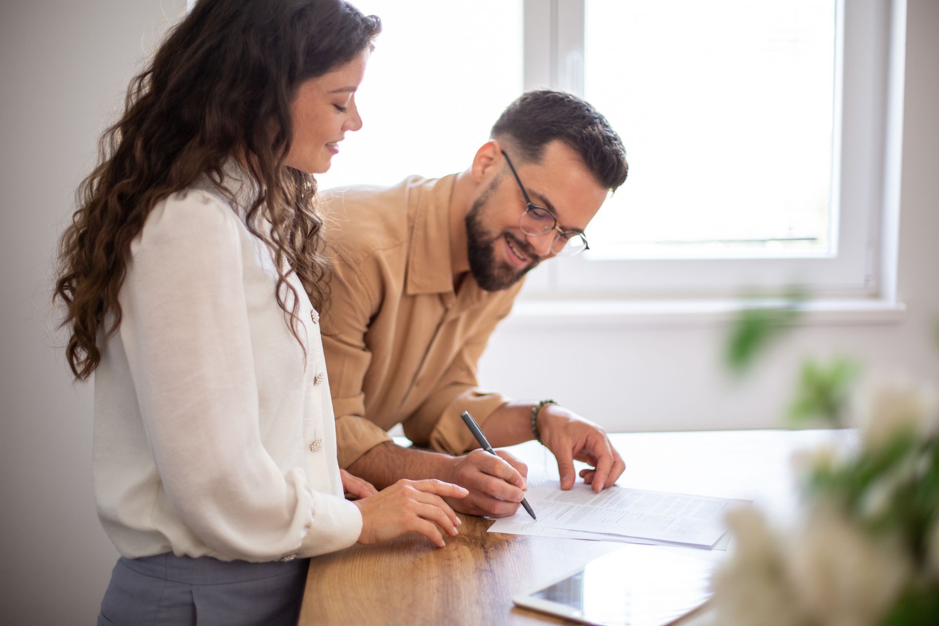 Couple signing documents for a real estate legal process.