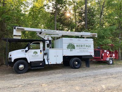 A white truck with a crane on top of it is parked next to a red truck.