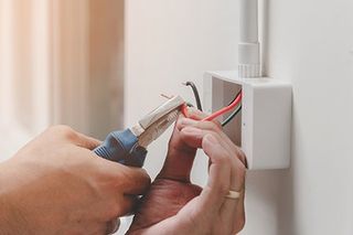 Electrician — Technician Is Using A Pliers Wrench To Install The Power Plug in Manheim, PA