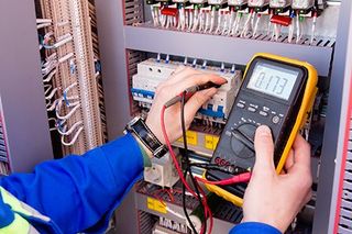 Electrical Upgrade — Multimeter Is In Hands Of Engineer In Electrical Cabinet  in Manheim, PA