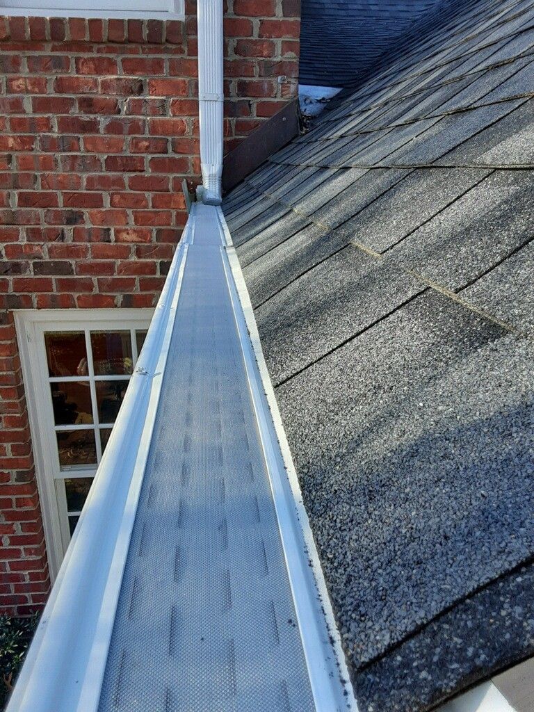 A close-up of a gutter on the side of a brick building - Lynchburg, VA - Leaf Relief Gutter Cleaning Service