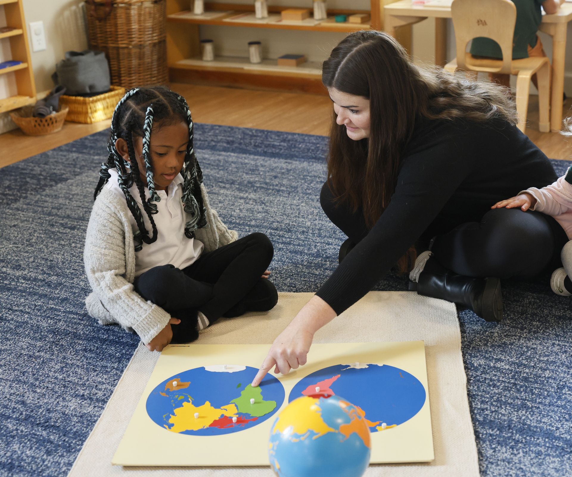 Montessori guide supporting their student's work