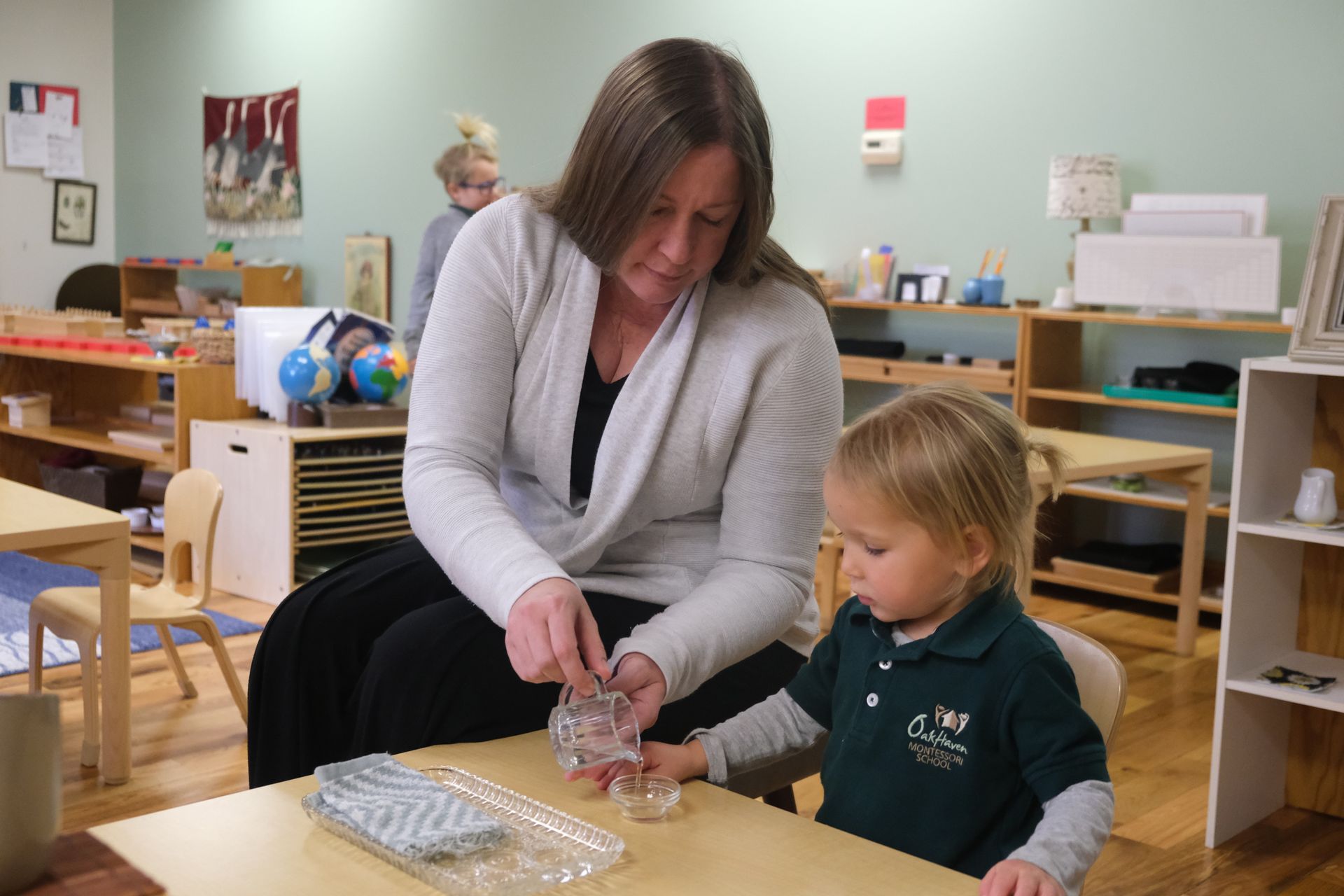 Montessori guide supporting their student's work