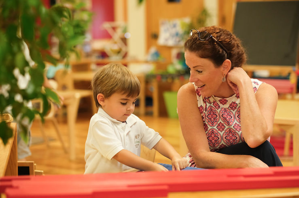 Montessori guide smiling at her student