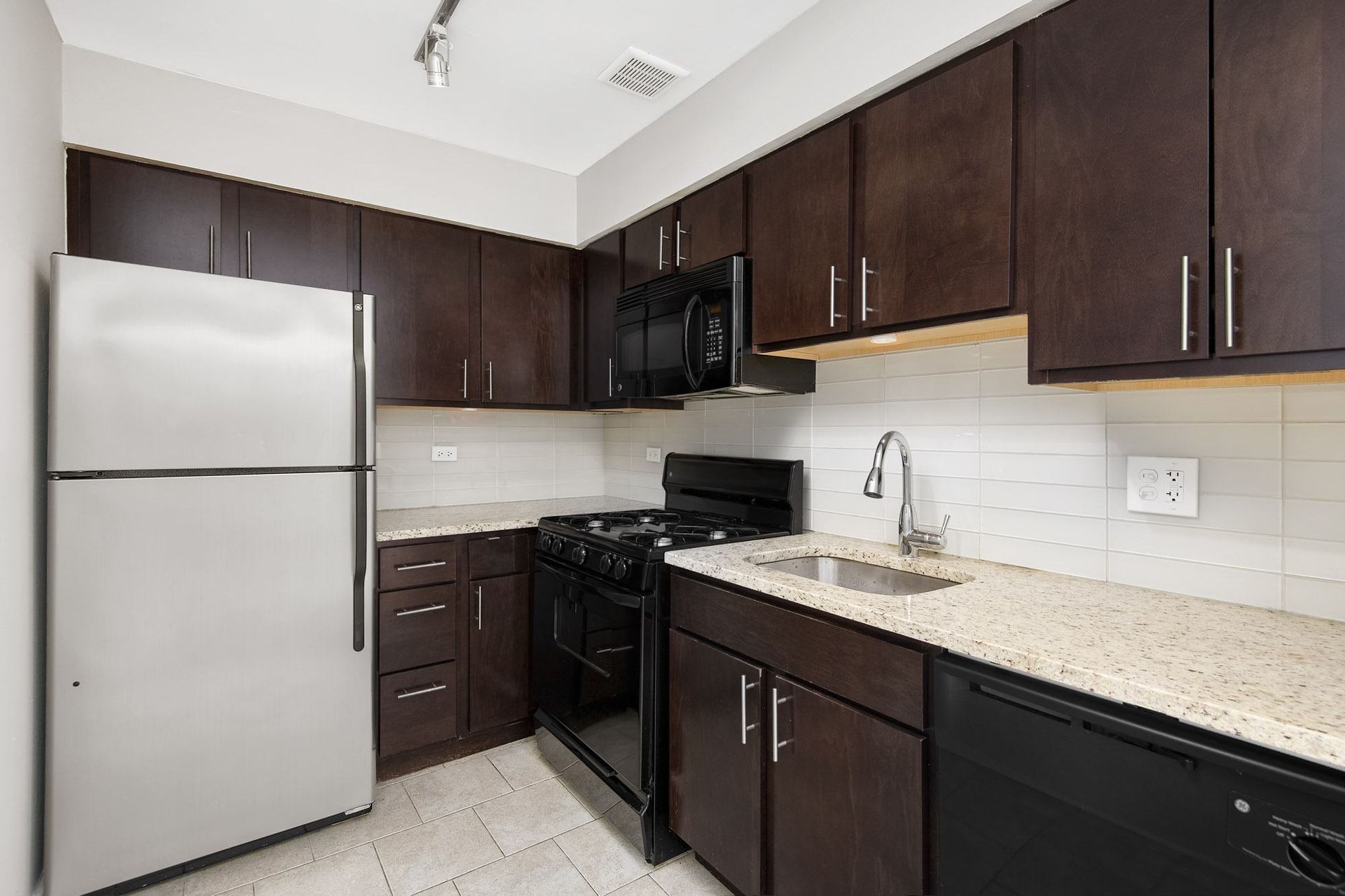 a kitchen with stainless steel appliances and marble counter tops