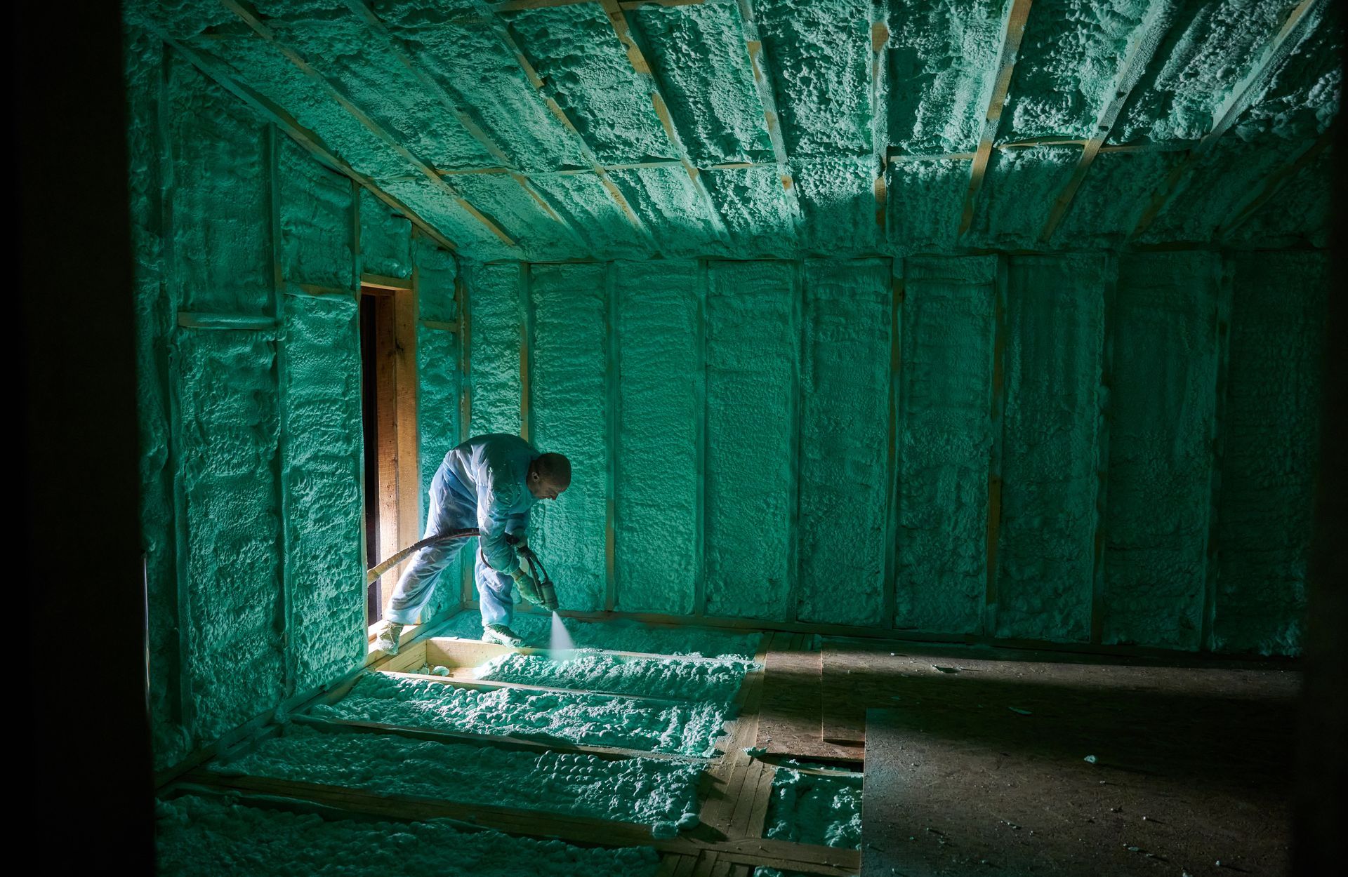 A man insulating walls along with floor and ceiling