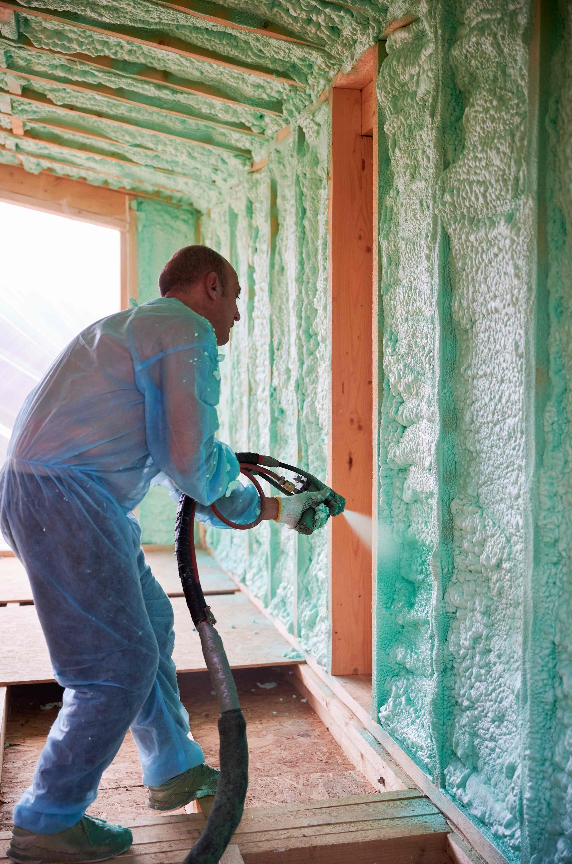 A man insulating a wall