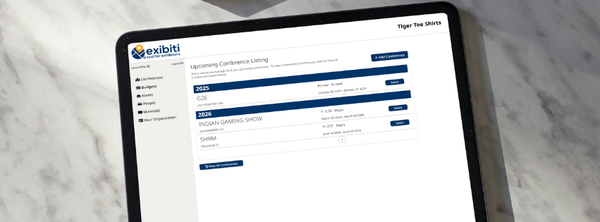 Tablet displaying data tables on a marble surface. The website logo is visible.