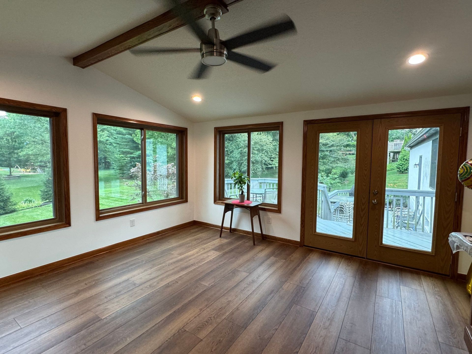 A room with a lot of windows and trees in the background