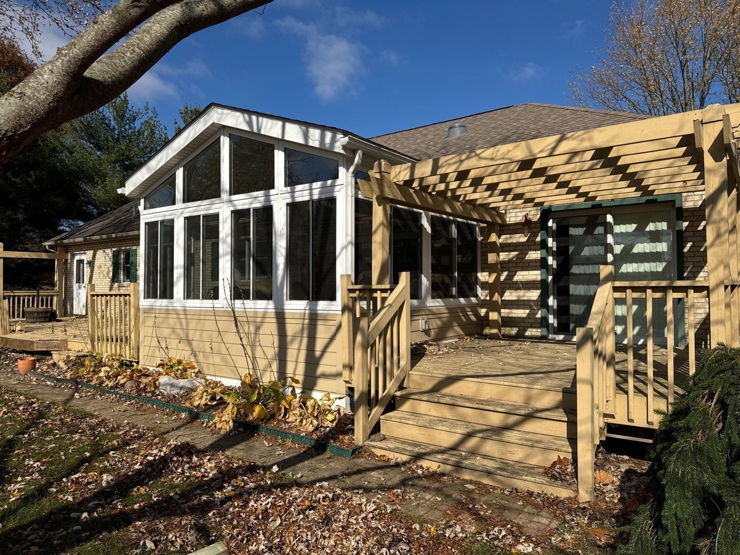 A house with a screened in porch on the side of it.