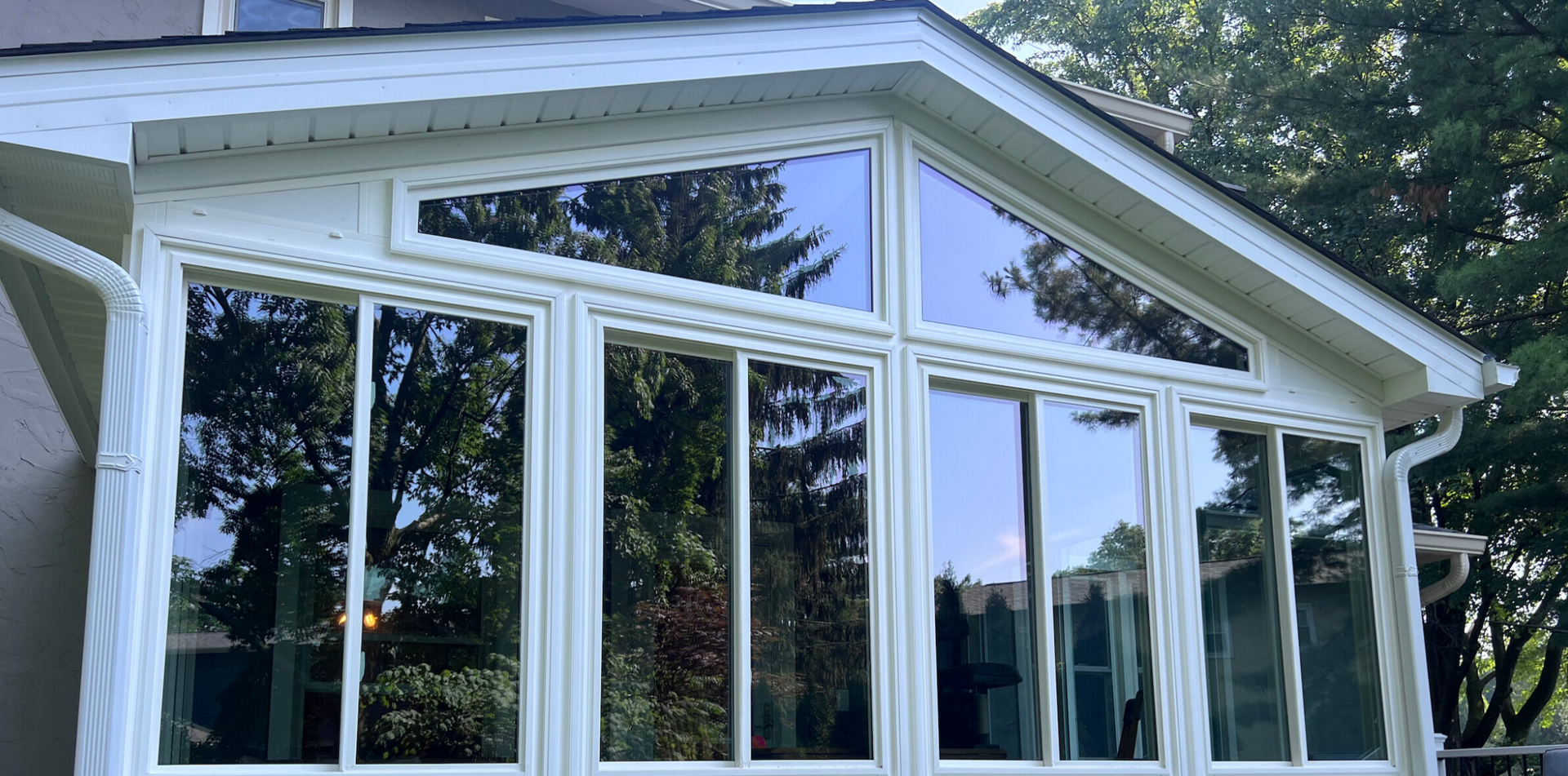 A house with a screened in porch on the side of it.