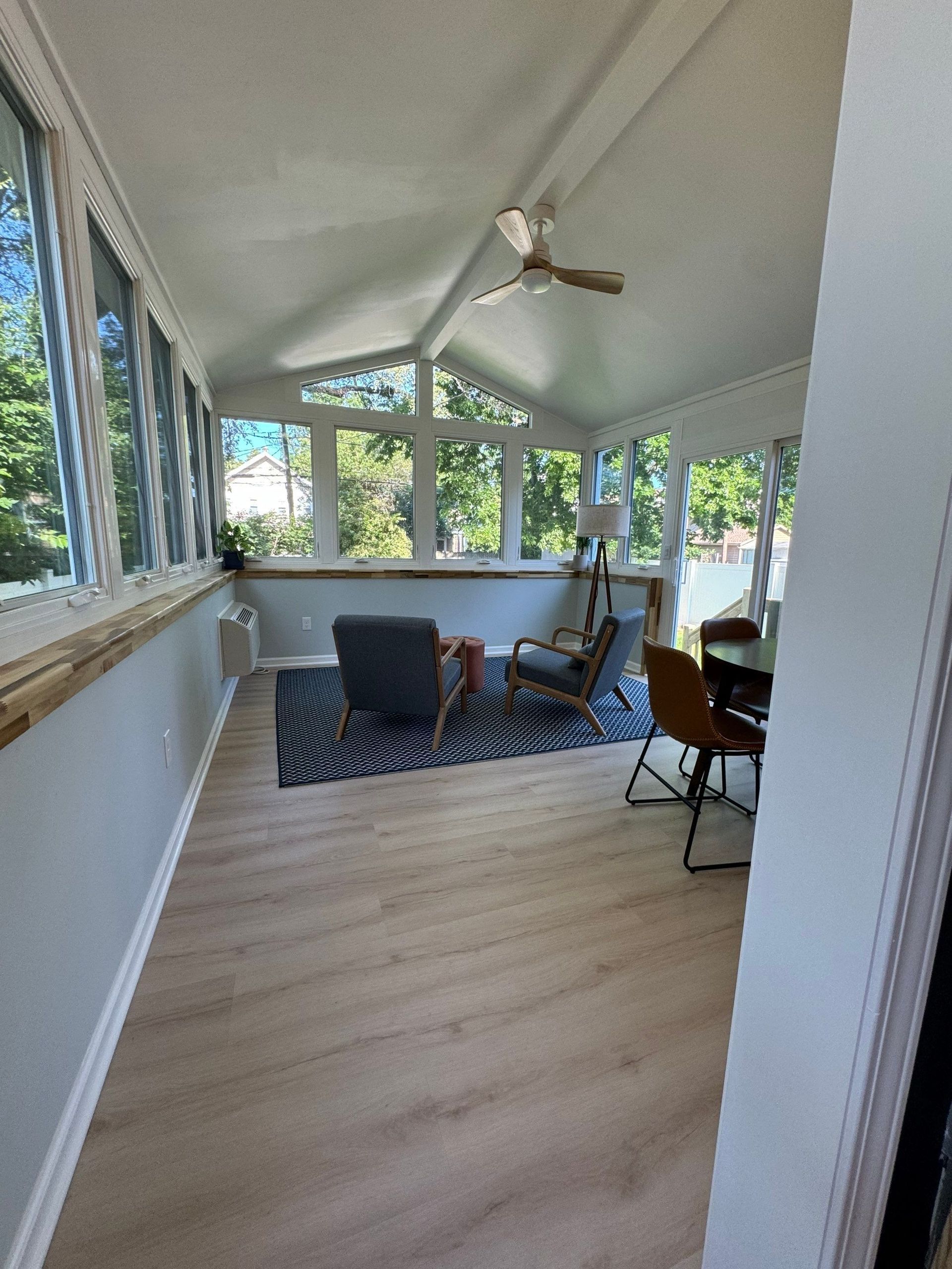 A room with a lot of windows and trees in the background