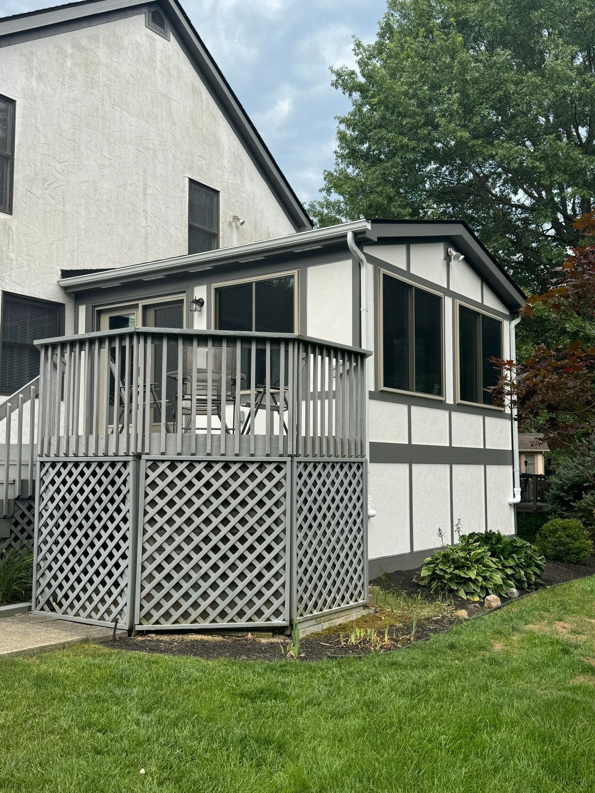 A house with a screened in porch on the side of it.