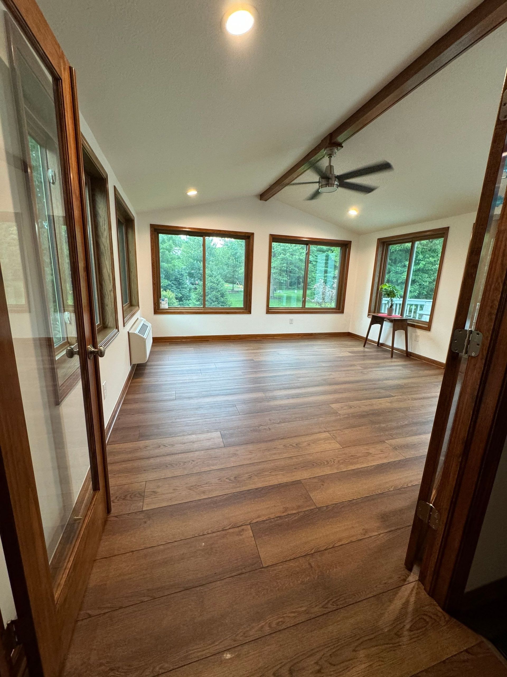 A room with a lot of windows and trees in the background