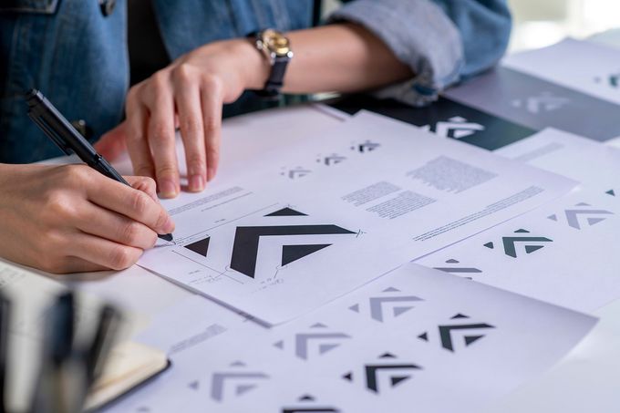 A person is sitting at a table writing on a piece of paper.