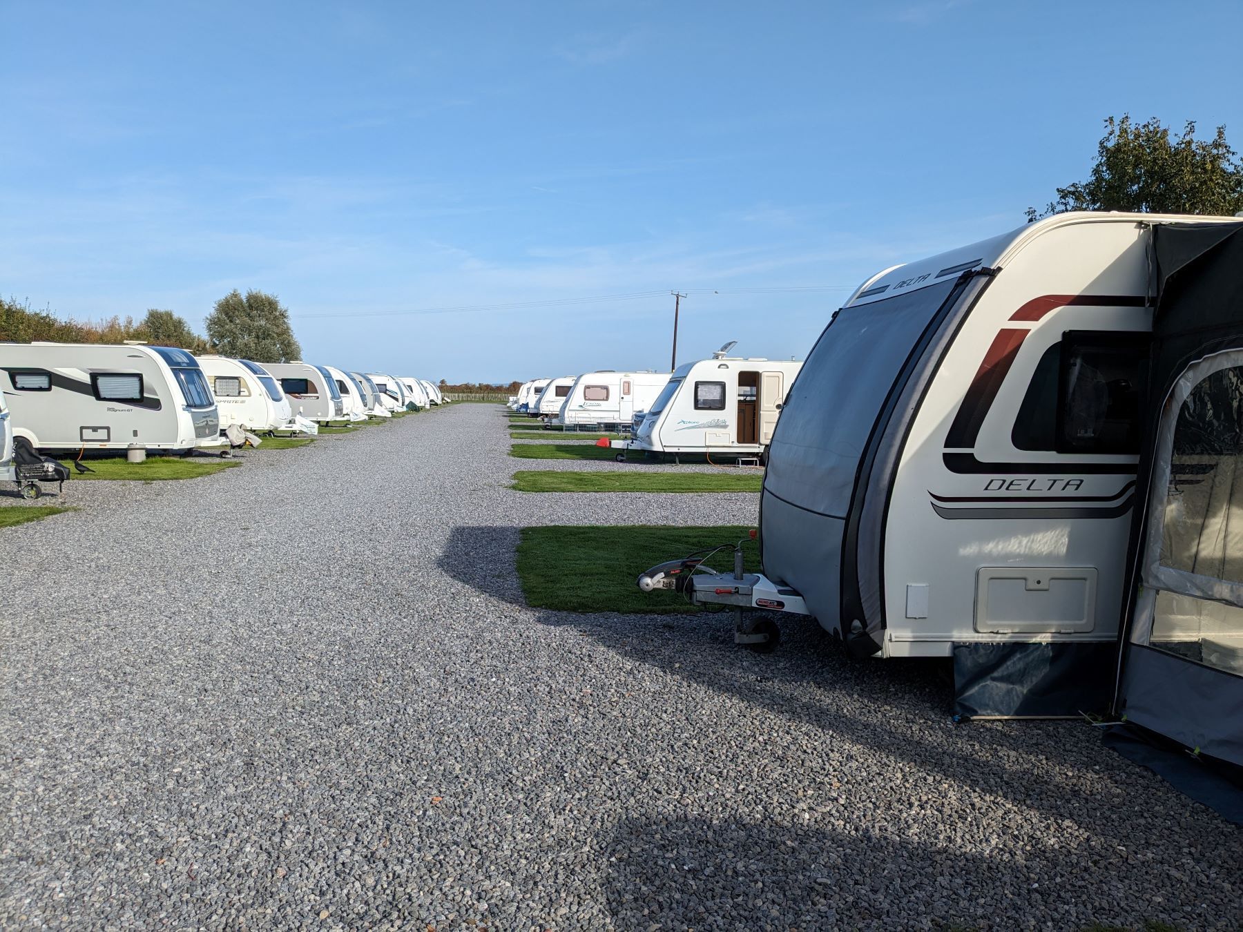 Touring caravans and motorhomes parked at a campsite in the UK countryside