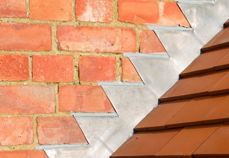 A close up of a brick wall and a roof