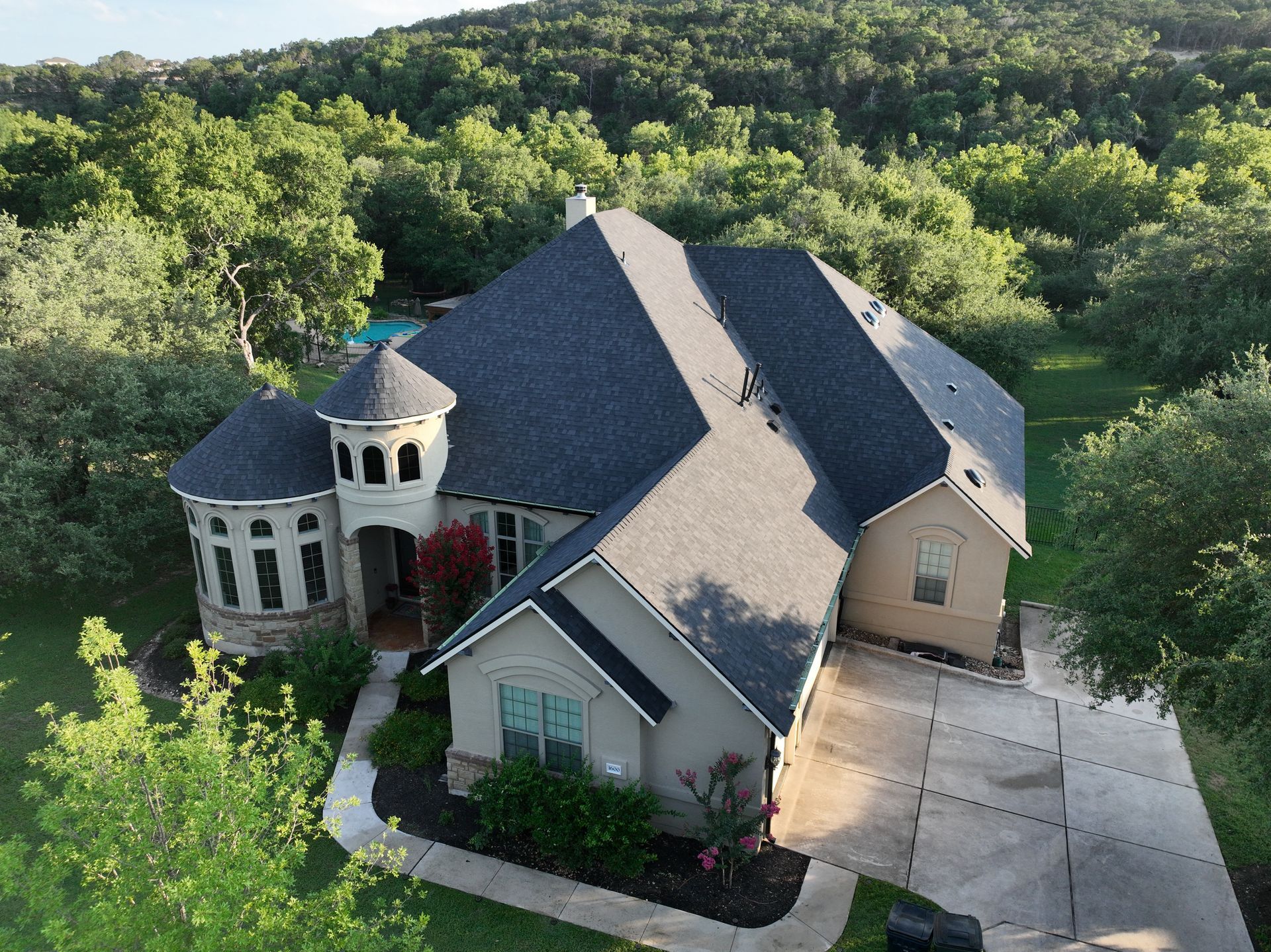 7,900 sqft home in Austin, TX, with Owens Corning Duration shingles in Onyx Black, hail-damaged roof replacement covered by insurance.