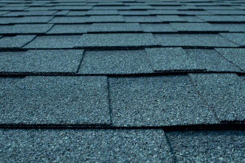 A close up of a roof with blue shingles