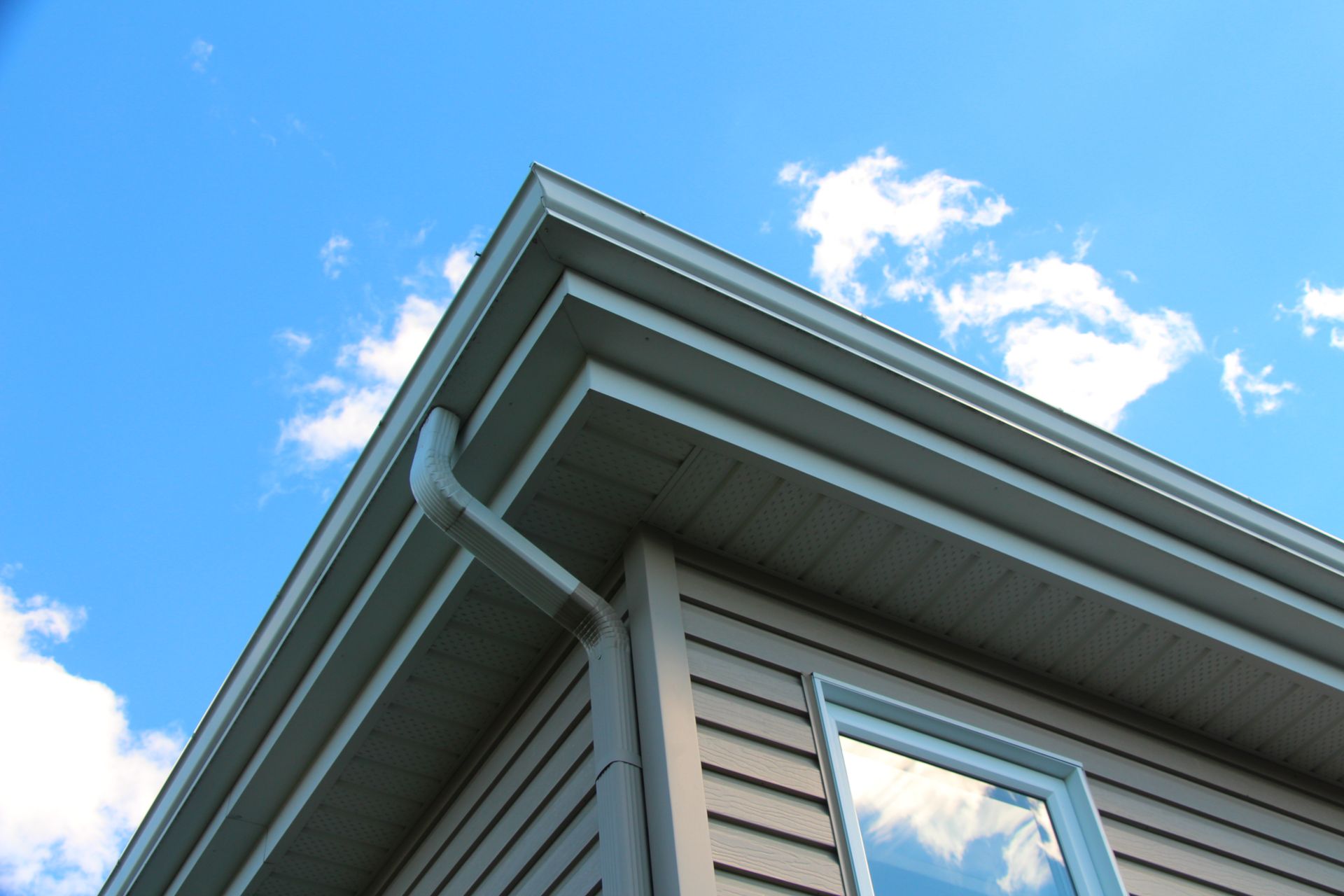 A house with a blue sky and clouds behind it