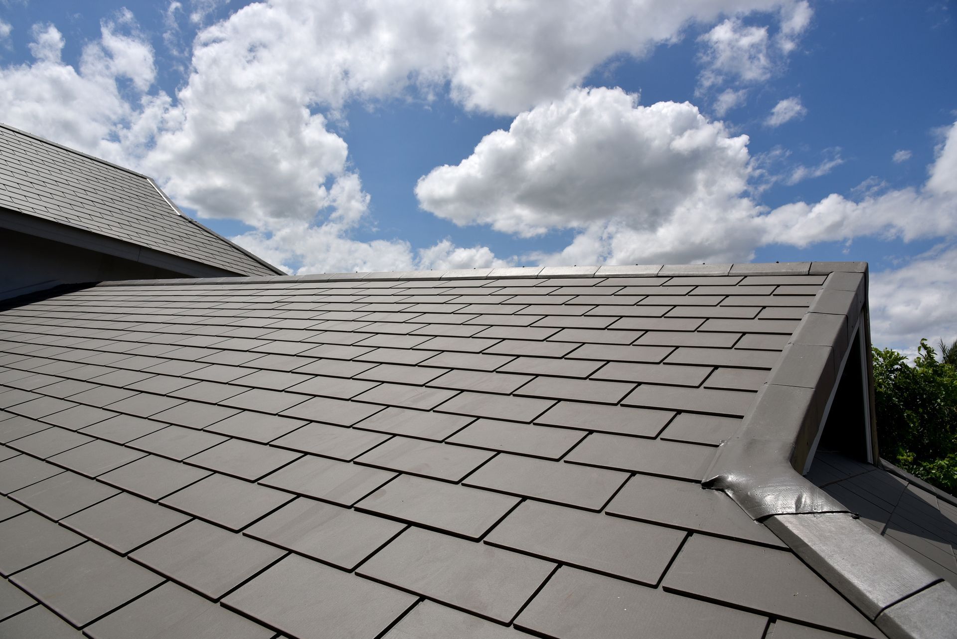 A man is standing on top of a white roof.