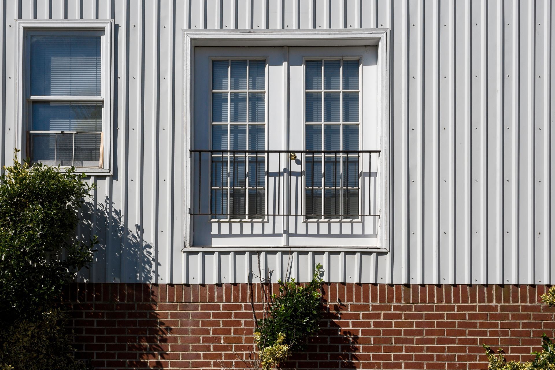 A white building with a brick wall and a window