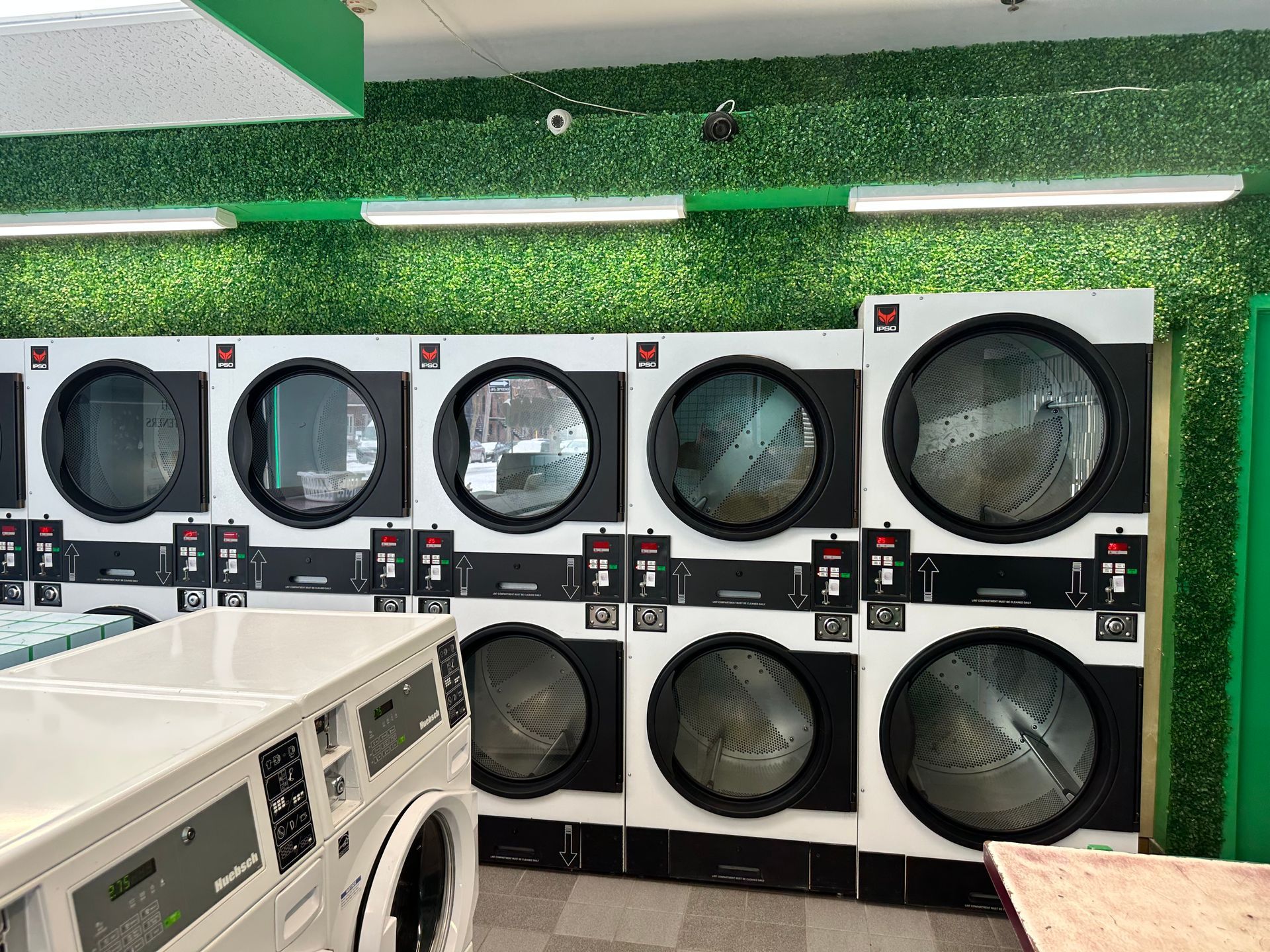 A man is standing at a table in a laundromat.